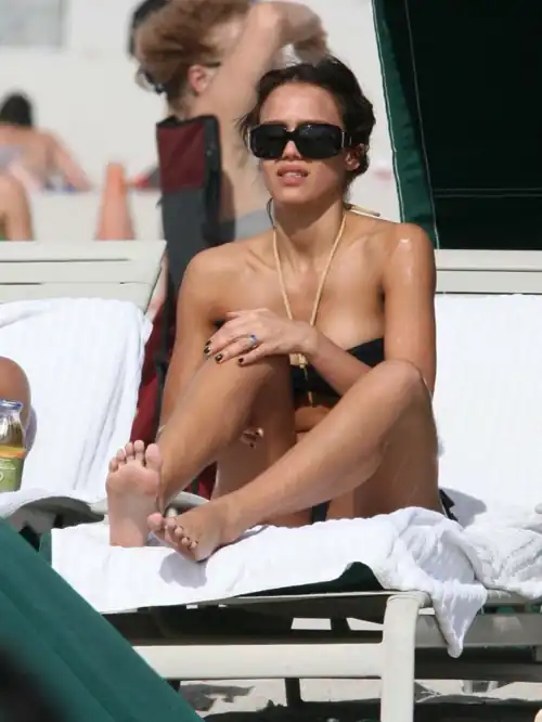Rubbing sunscreen on her legs