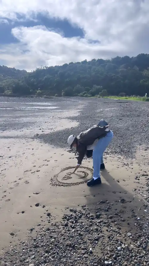 Drawing heart eyes in the sand 6/26/2024