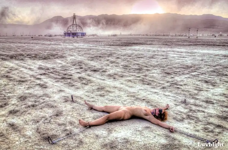 "Martian Sacrifice". This was the last photo I took of Dee chained to the playa at Burning Man 2004. A dust storm arose from the northwest, and you can see the clouds rushing to engulf her.