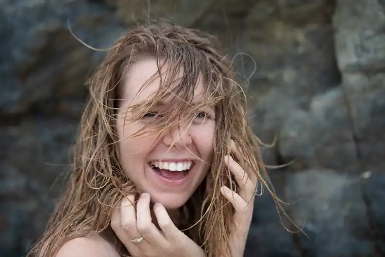 Laughing off getting hit by a wave at the beach haha