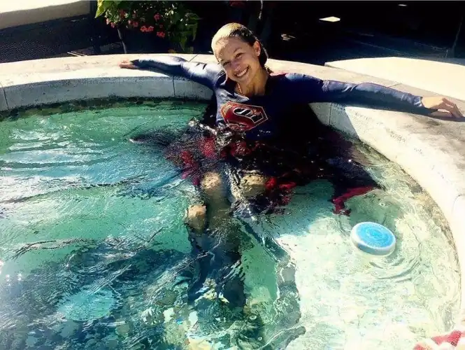 Melissa in a pool in her Supergirl costume