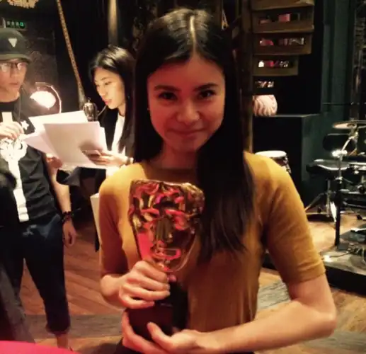 Katie holding her "Breakthrough Brit" BAFTA