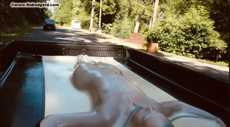 Restrained in a vacbed on the flatbed of a truck and driven through town.