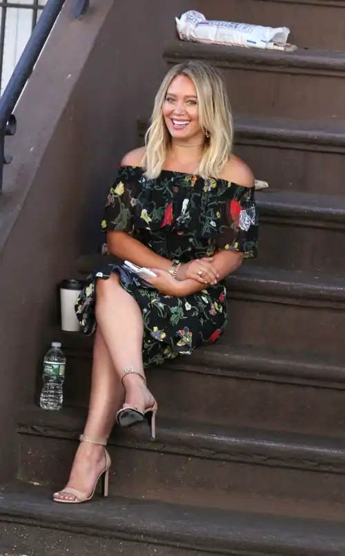 Hilary is all smiles sitting on the steps